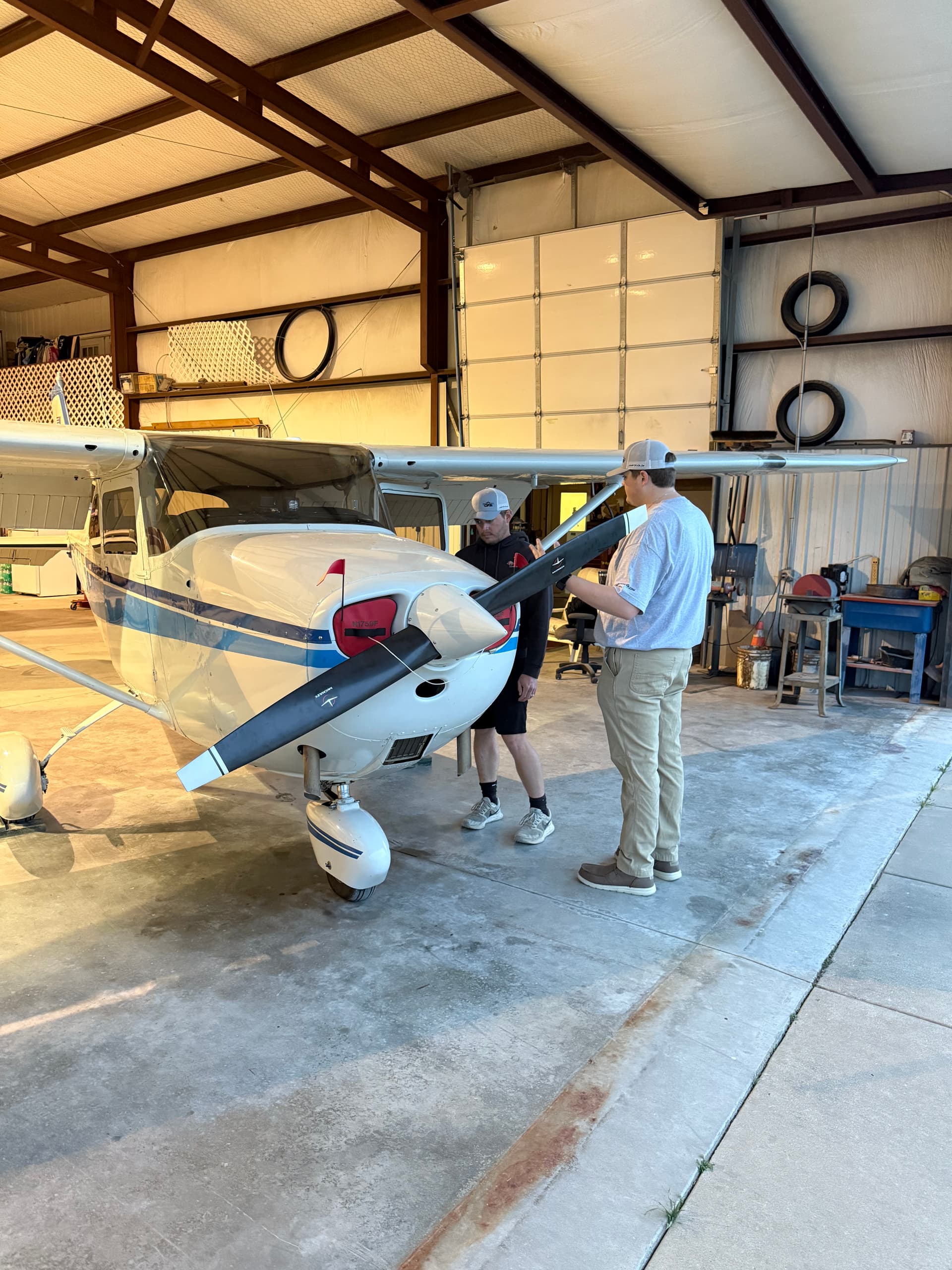 Oklahoma Flight Academy students with a training aircraft in the hangar