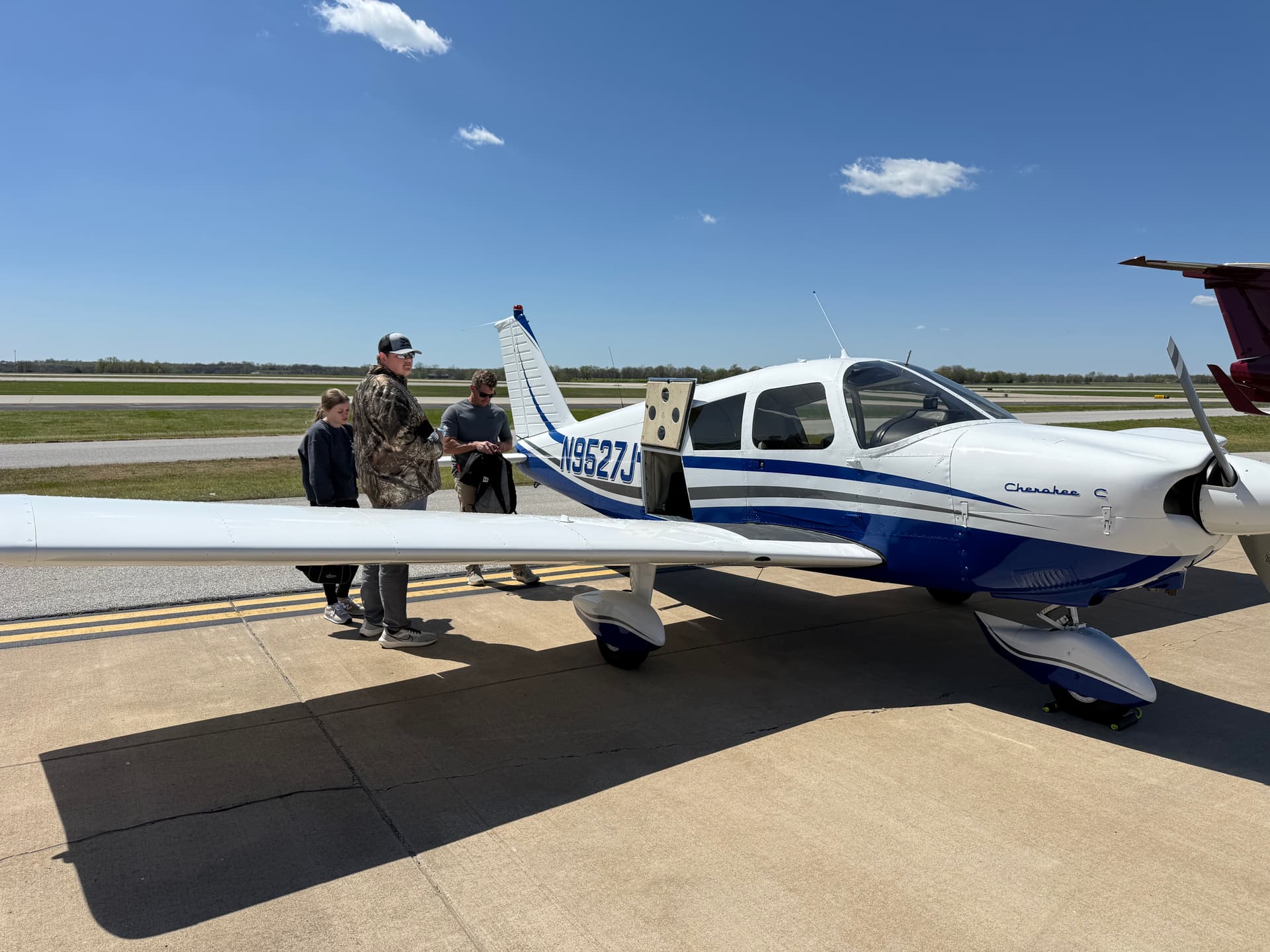 Oklahoma Flight Academy students beside the academy’s Piper Cherokee N9527J on the ramp under a clear Oklahoma sky